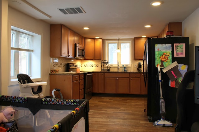 kitchen with wood finished floors, visible vents, recessed lighting, stainless steel appliances, and decorative backsplash