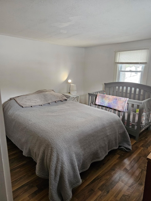 bedroom featuring wood finished floors and a textured ceiling