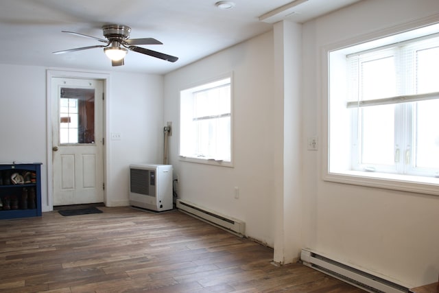 unfurnished room with wood finished floors, a ceiling fan, and a baseboard radiator