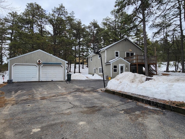 view of home's exterior with a detached garage, an outbuilding, and a deck