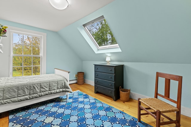 323 Runaround Pond Rd, Durham, ME 04222 - bedroom with a skylight, a baseboard radiator, lofted ceiling, and light wood-style flooring