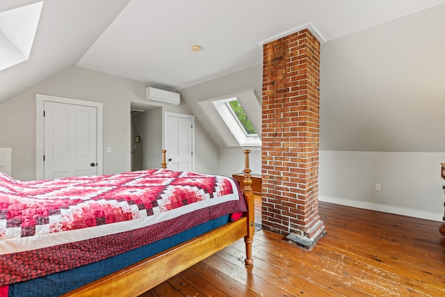 323 Runaround Pond Rd, Durham, ME 04222 - bedroom with an AC wall unit, wood-type flooring, vaulted ceiling, a skylight, and baseboards