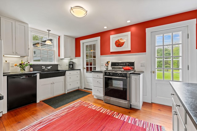 323 Runaround Pond Rd, Durham, ME 04222 - kitchen with gas stove, black dishwasher, dark countertops, light wood-type flooring, and recessed lighting