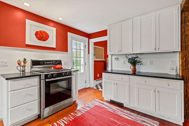 323 Runaround Pond Rd, Durham, ME 04222 - kitchen featuring stainless steel gas range, light wood-style flooring, dark countertops, white cabinetry, and baseboard heating