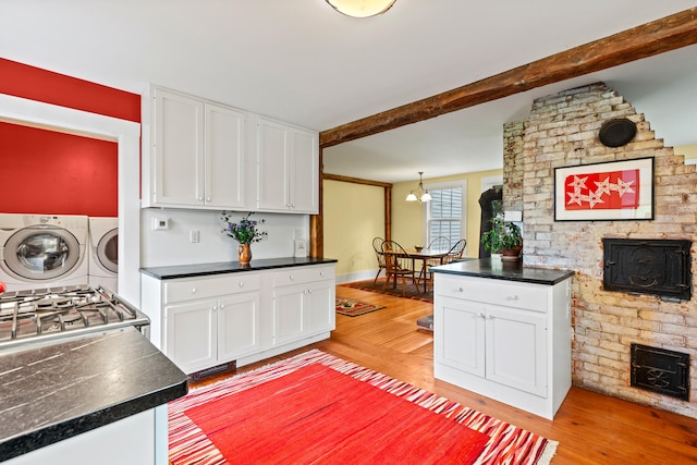323 Runaround Pond Rd, Durham, ME 04222 - kitchen with independent washer and dryer, light wood finished floors, white cabinetry, and beam ceiling