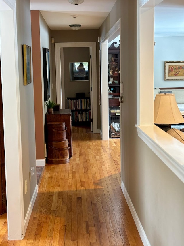 hall featuring hardwood / wood-style floors and baseboards