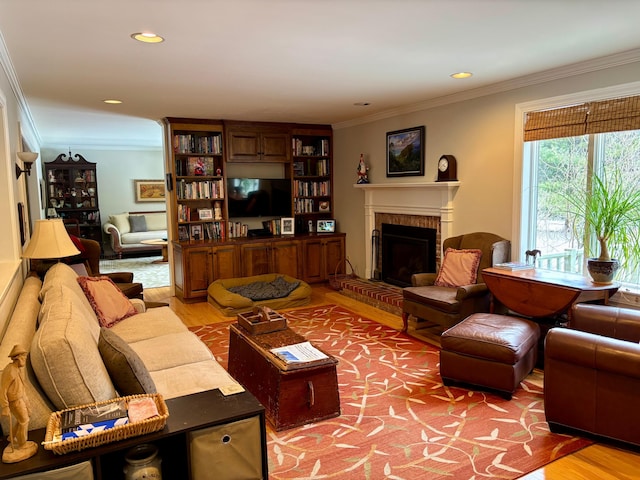 living area featuring recessed lighting, a fireplace, crown molding, and light wood finished floors