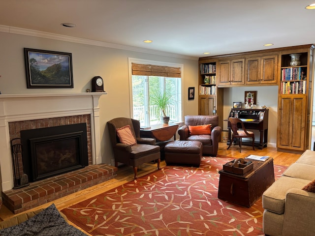 living area featuring recessed lighting, a fireplace, light wood-type flooring, and crown molding