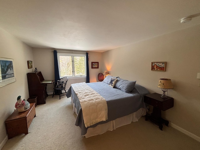 bedroom featuring light carpet and baseboards