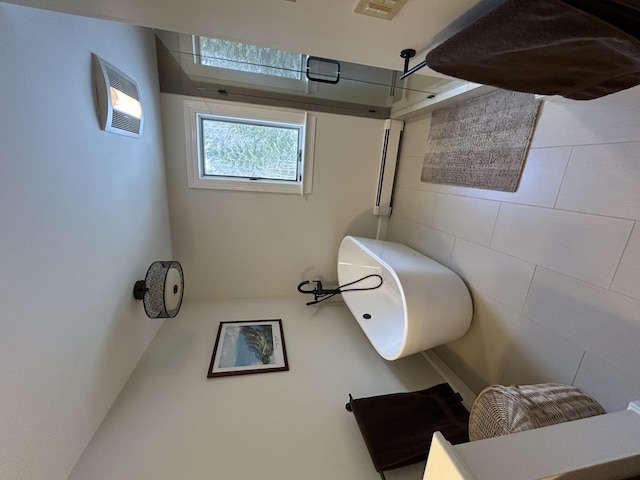 bathroom with a shower and tile walls