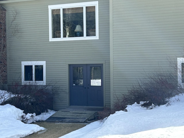 snow covered property entrance with french doors