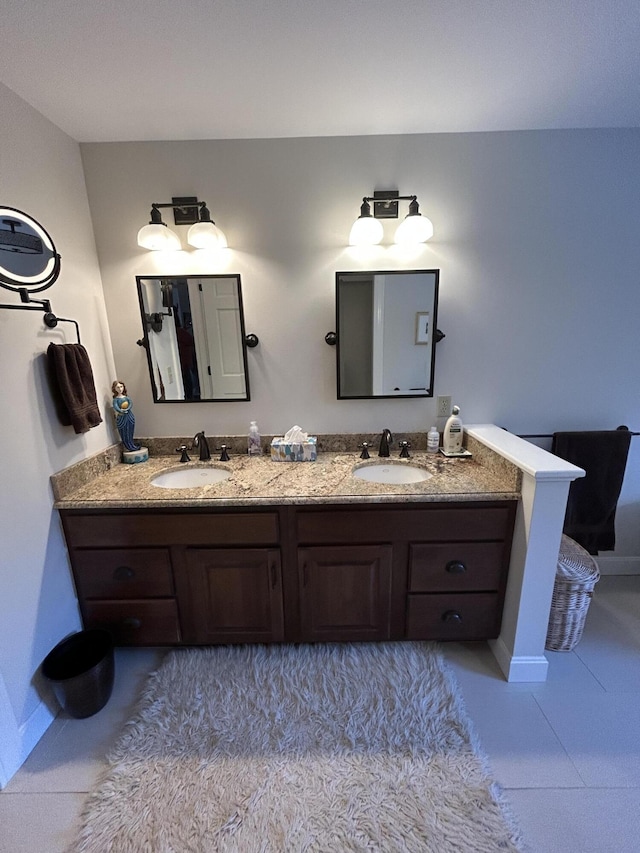 bathroom featuring tile patterned flooring, double vanity, and a sink