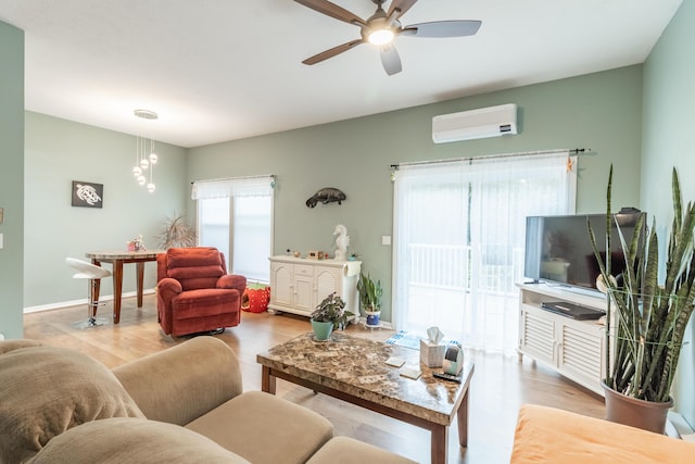 living area with baseboards, a ceiling fan, wood finished floors, and a wall mounted air conditioner