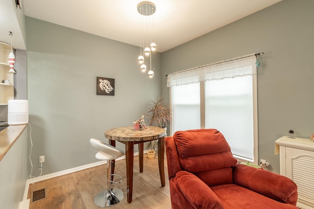 living area featuring light wood-style floors, baseboards, and visible vents