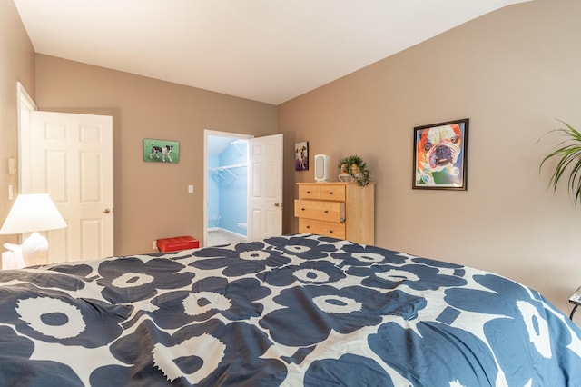 bedroom with lofted ceiling and a spacious closet