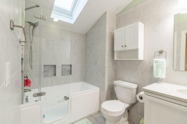 bathroom with lofted ceiling with skylight, shower / bath combination, vanity, and tile walls