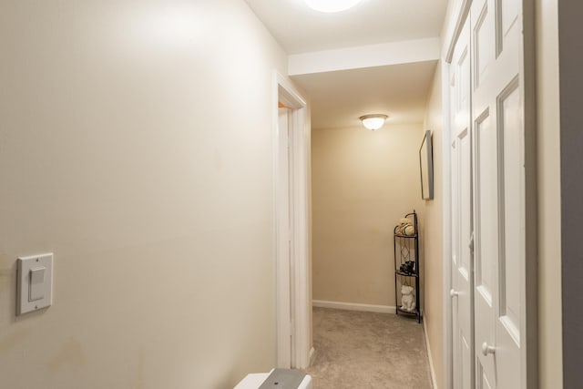 corridor featuring light carpet and baseboards