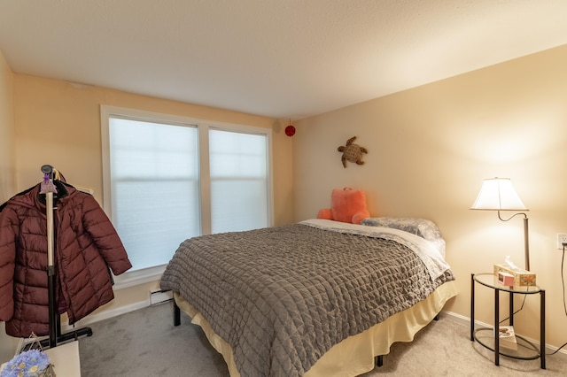 bedroom with baseboards, a baseboard heating unit, and carpet flooring