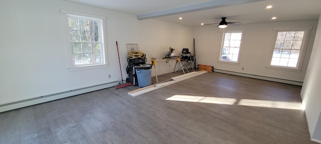 interior space featuring plenty of natural light, baseboard heating, and wood finished floors