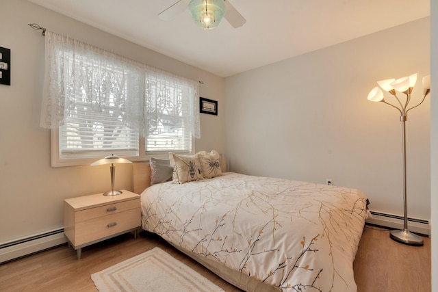 bedroom with baseboard heating, a ceiling fan, and wood finished floors