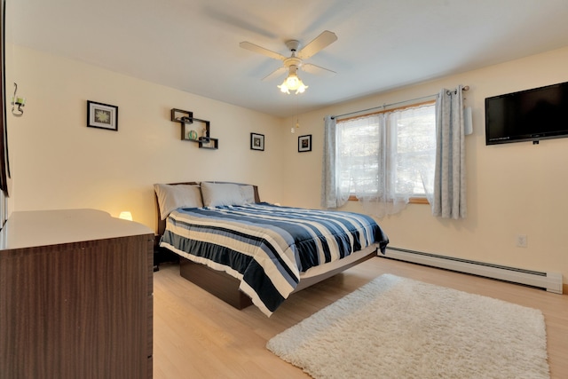 bedroom featuring a ceiling fan, light wood-type flooring, and a baseboard radiator