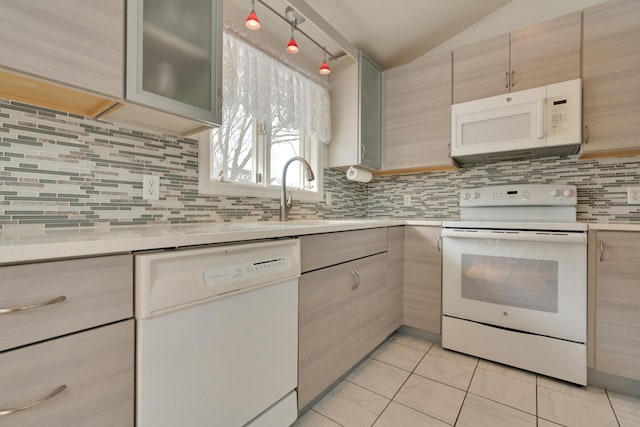 kitchen with light tile patterned floors, white appliances, tasteful backsplash, and light countertops