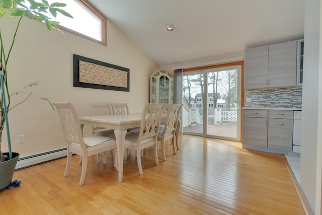 dining area with plenty of natural light, light wood finished floors, and a baseboard radiator