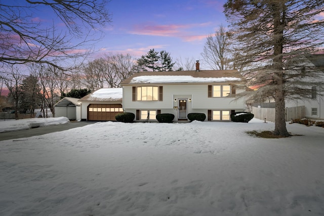 view of front of property with an attached garage, a chimney, and fence