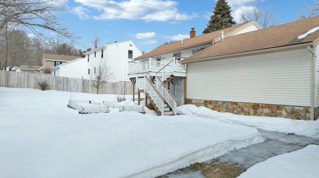 exterior space featuring stairs, fence, and a wooden deck