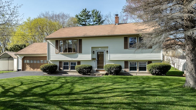 72 Bay St, Portland, ME 04103 - raised ranch featuring a shingled roof, a garage, a front yard, a chimney, and driveway