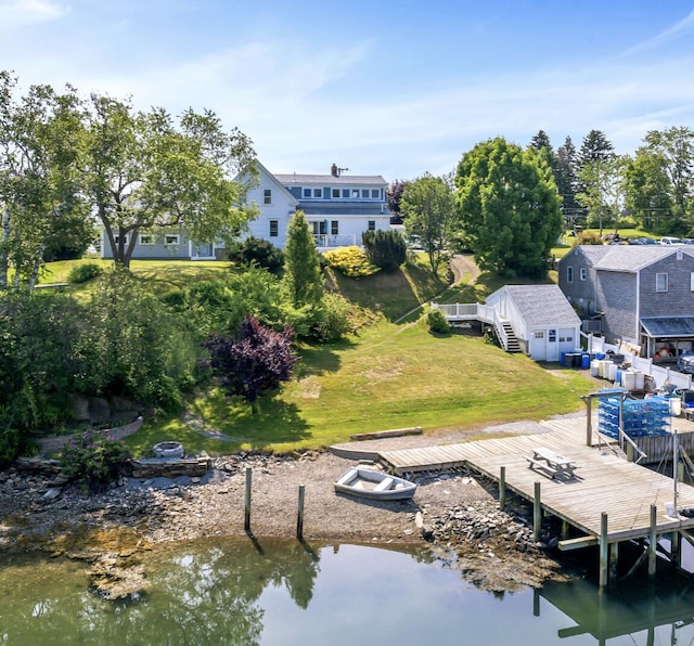 dock area featuring a fire pit, a yard, and a deck with water view