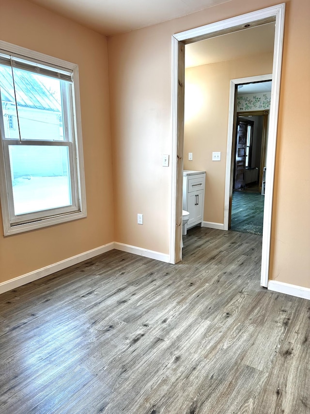 spare room featuring wood finished floors and baseboards