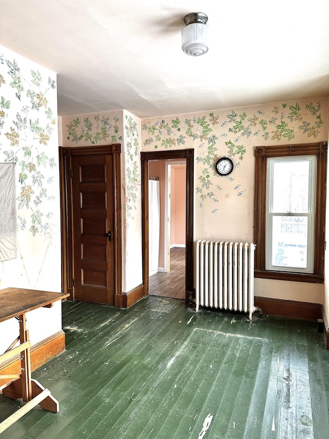 foyer entrance featuring wallpapered walls, radiator, baseboards, and wood-type flooring