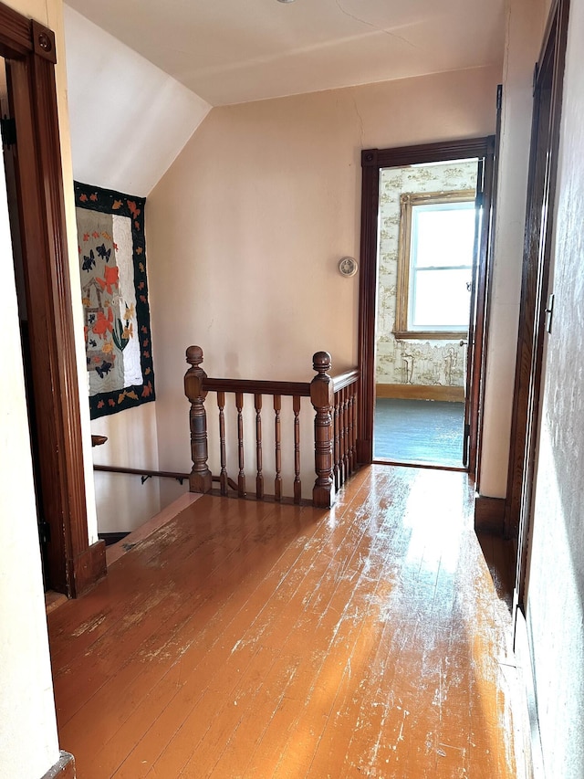 corridor featuring an upstairs landing, lofted ceiling, and hardwood / wood-style floors