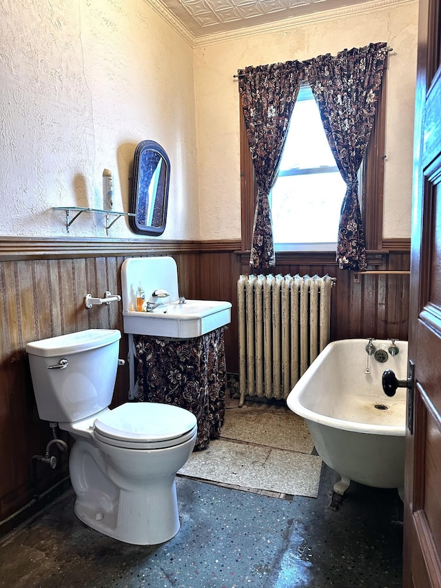 full bath with an ornate ceiling, radiator, wood walls, and wainscoting