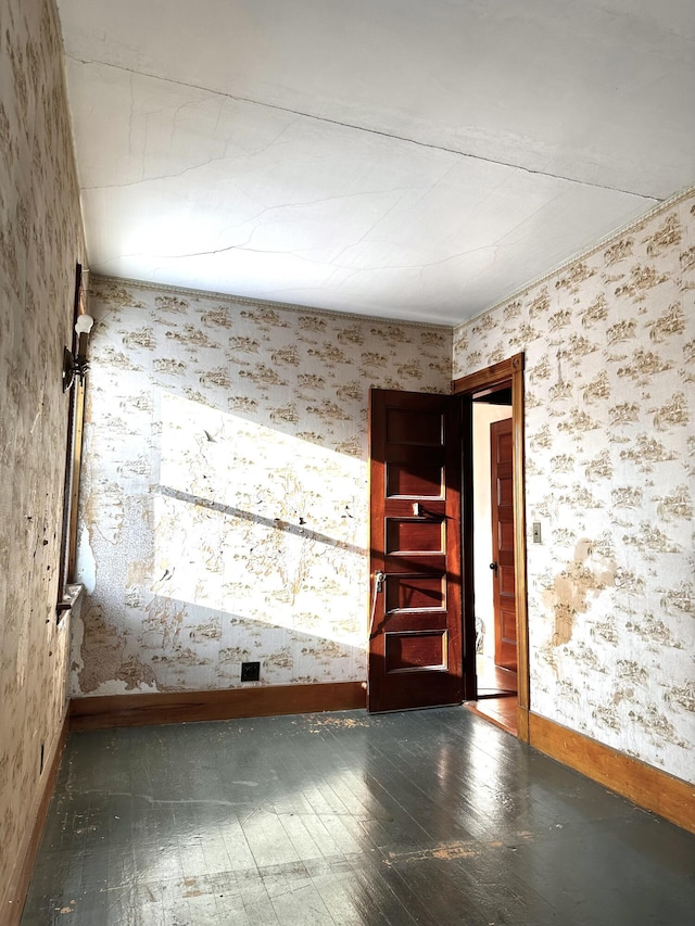 empty room with wallpapered walls and baseboards