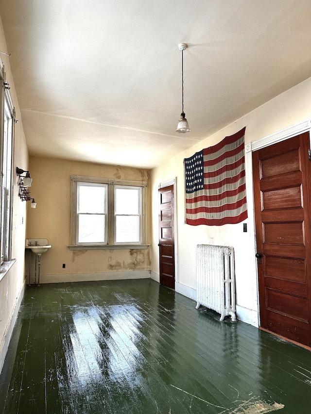 unfurnished living room featuring baseboards and hardwood / wood-style flooring