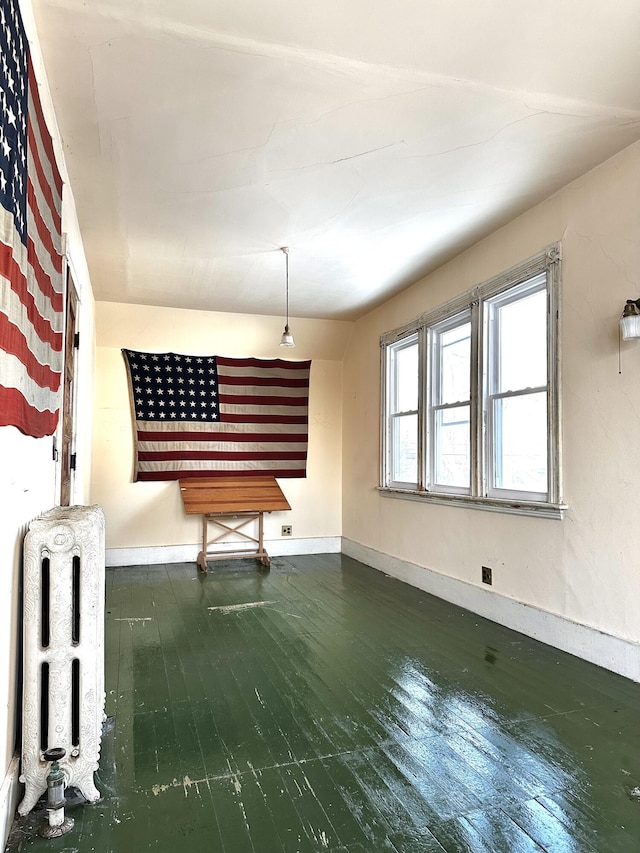 interior space with hardwood / wood-style flooring, radiator, and baseboards