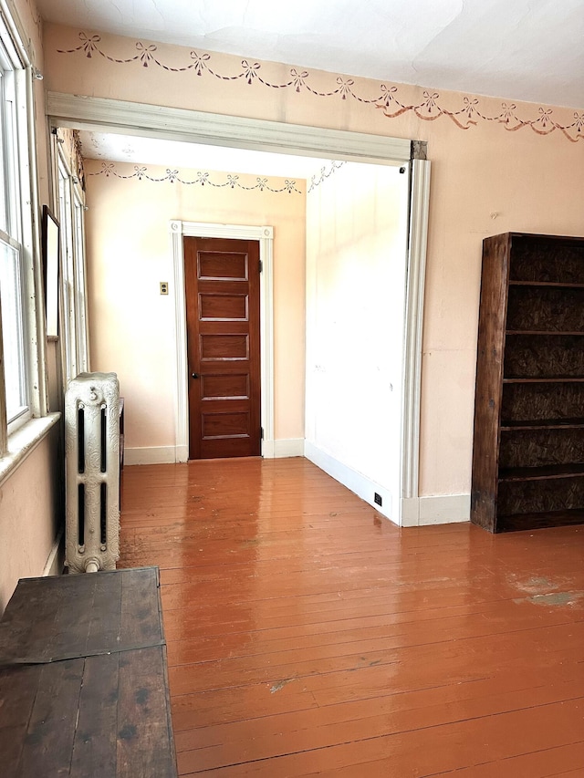 interior space featuring hardwood / wood-style floors, plenty of natural light, and radiator heating unit