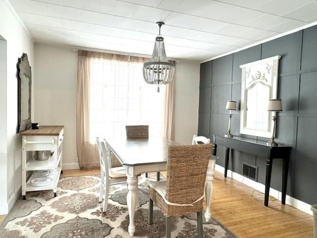 dining space featuring visible vents, baseboards, light wood-type flooring, and an inviting chandelier