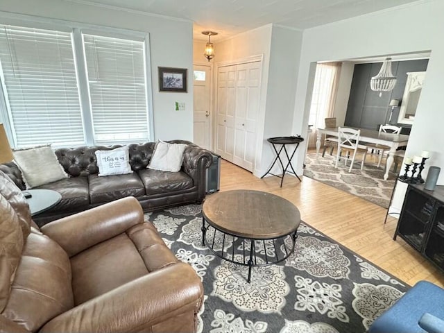 living room featuring crown molding, an inviting chandelier, and wood finished floors