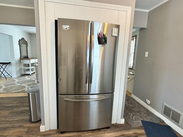 kitchen featuring visible vents, ornamental molding, dark wood finished floors, freestanding refrigerator, and baseboards