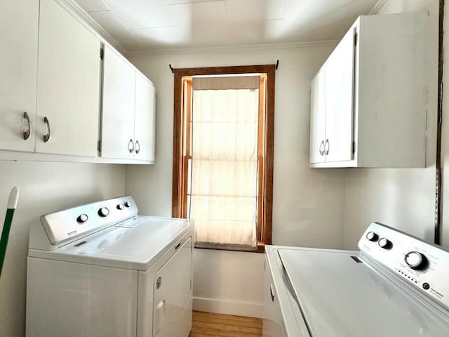 laundry area featuring baseboards, cabinet space, independent washer and dryer, and light wood-style flooring