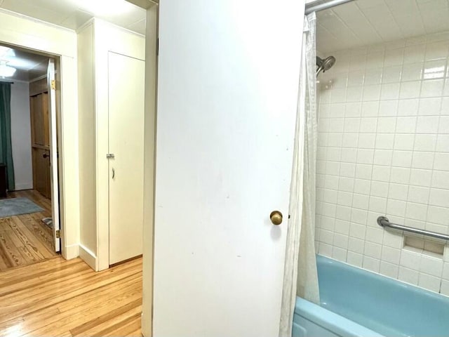 full bath featuring shower / bath combo with shower curtain and wood finished floors