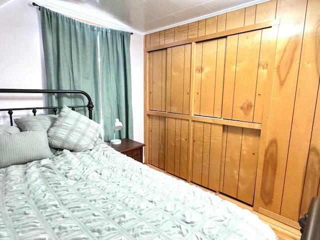 unfurnished bedroom with wooden walls and crown molding