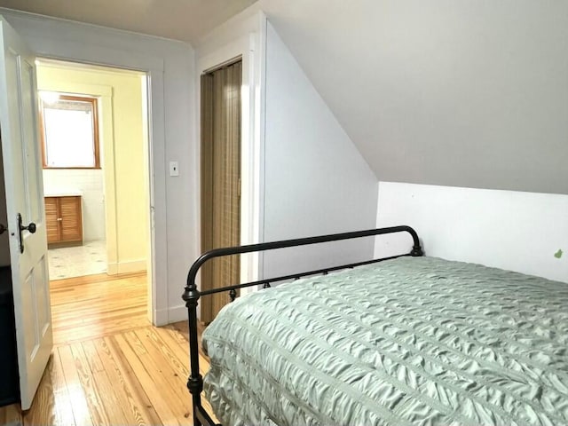 bedroom with vaulted ceiling and hardwood / wood-style flooring