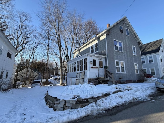 view of front of property featuring a chimney and a sunroom