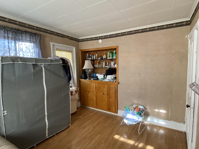 interior space with ornamental molding and wood finished floors