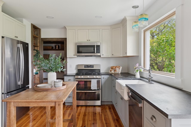 463 Back Meadow Rd, Damariscotta, ME 04543 - kitchen featuring appliances with stainless steel finishes, wood finished floors, a sink, dark countertops, and decorative light fixtures