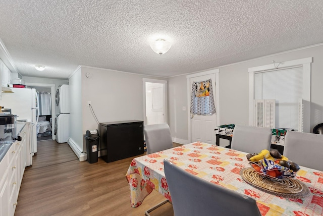 dining space with light wood-type flooring, baseboards, a textured ceiling, and a baseboard radiator